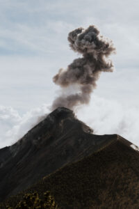 the eruption of Fuego Volcano, with clouds of ash spewing into the sky