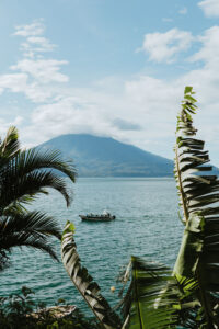 Sunny day over Lake Atitlan with lancha and volcano